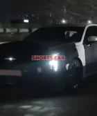 Un coche negro moviéndose de noche en la carretera.