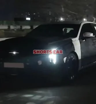 Un coche negro moviéndose de noche en la carretera.