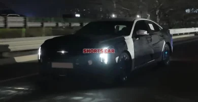 Un coche negro moviéndose de noche en la carretera.