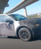 Automóvil con camuflaje de prueba en carretera y sobre puente.