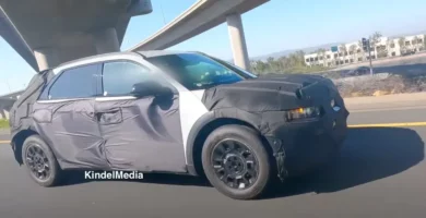 Automóvil con camuflaje de prueba en carretera y sobre puente.