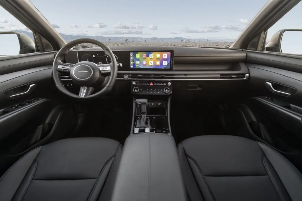 Interior de un automóvil moderno con pantalla táctil y asientos de cuero.