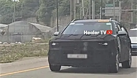 Vehículo negro con emblema oculto y posible camuflaje para pruebas.