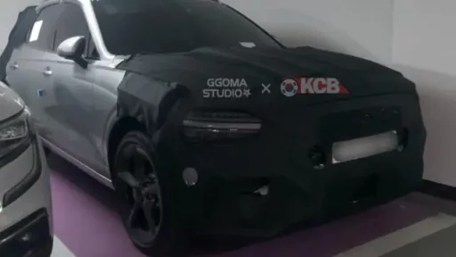Automóvil deportivo negro con camuflaje de prueba estacionado.