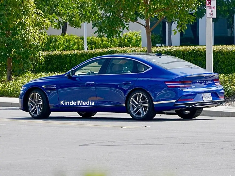 Un automóvil Genesis azul estacionado junto a la acera.