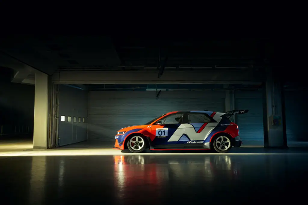 Auto de carreras en un garaje iluminado por un haz de luz.