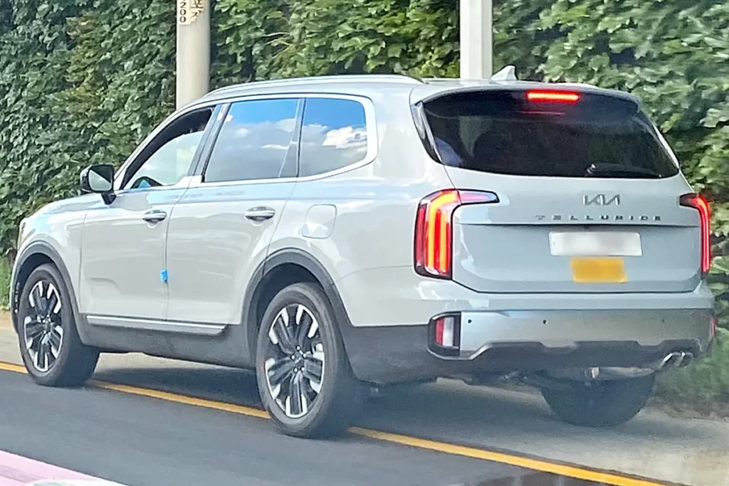 Kia Telluride blanco circulando en una carretera.