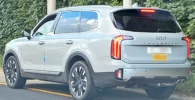 Kia Telluride blanco circulando en una carretera.