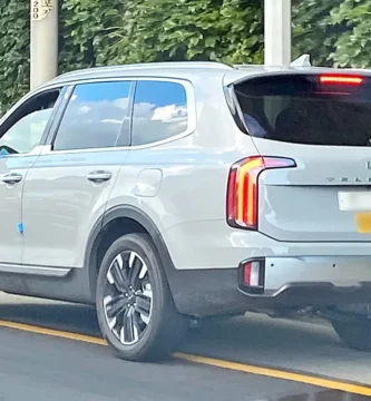 Kia Telluride blanco circulando en una carretera.