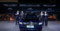 Presentación de un coche nuevo Genesis G80 con cuatro hombres.