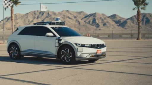 Vehículo autónomo blanco con sensores en desierto montañoso.