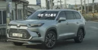 Un Toyota SUV plateado en una calle con texto en coreano.