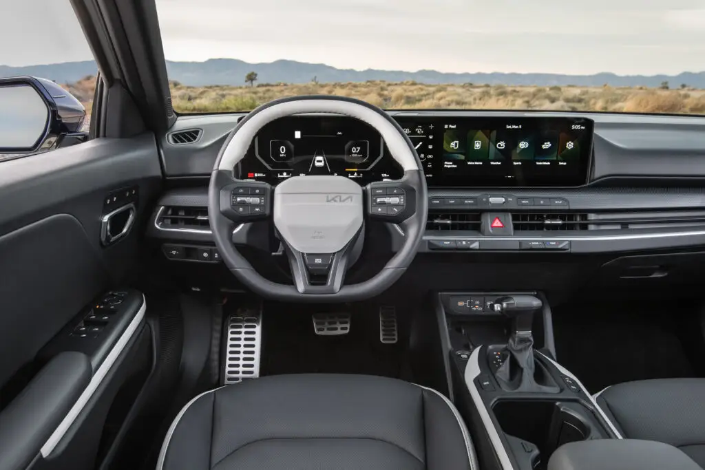 Interior moderno de vehículo con pantallas digitales y acabados elegantes.