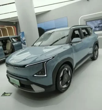 Sala de exhibición con dos vehículos eléctricos Kia azules.