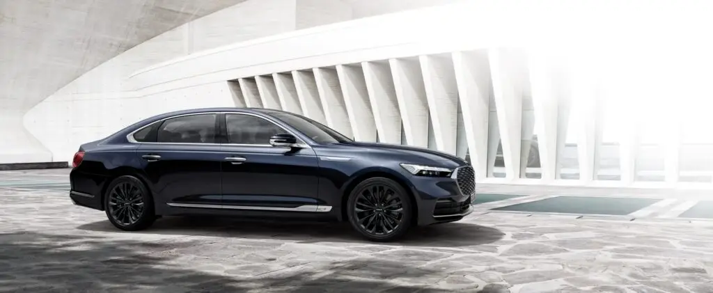 Auto de lujo negro estacionado en una estructura moderna de concreto.