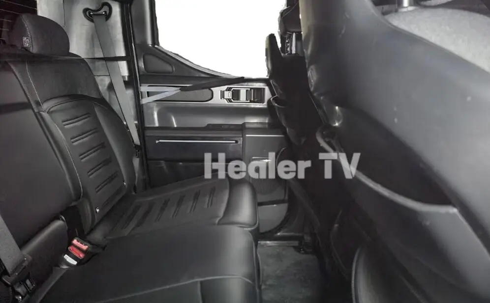 Interior de un vehículo, asientos traseros de cuero negro.