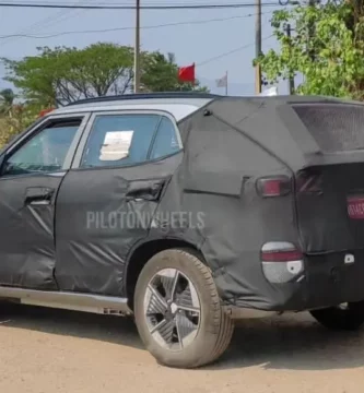 Auto cubierto con lona negra, posiblemente camuflaje para pruebas.