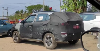 Auto cubierto con lona negra, posiblemente camuflaje para pruebas.