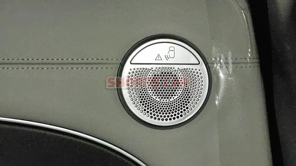 Altavoz de un automóvil con iconos de advertencia y ajuste.