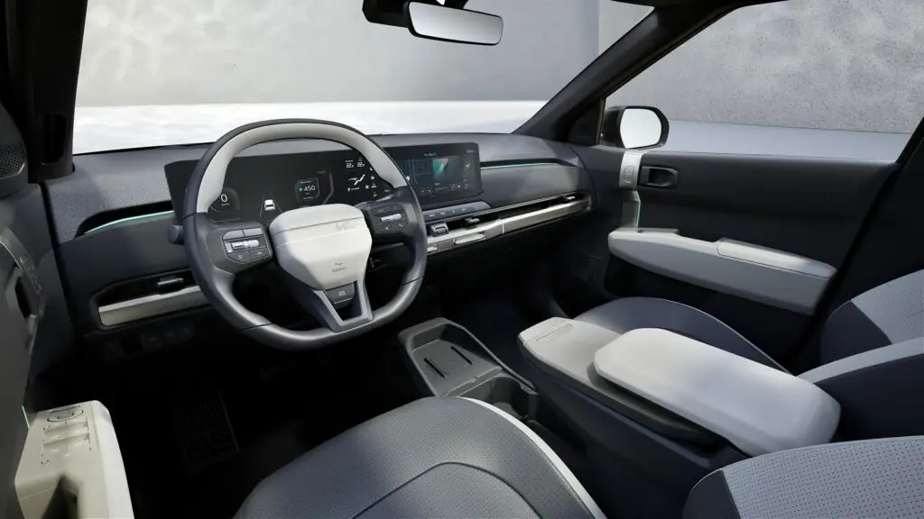 Interior moderno de automóvil con pantalla digital y volante multifuncional.