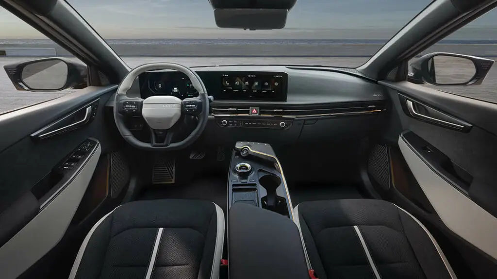 Interior moderno de un automóvil con volante rectangular y pantalla táctil.