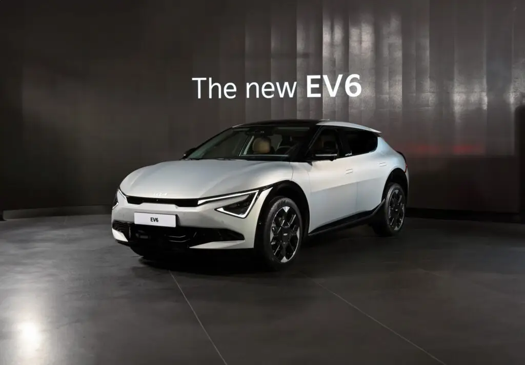 Auto eléctrico EV6, color blanco, exhibido en un ambiente oscuro.