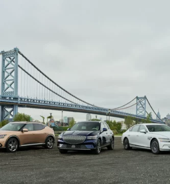 Tres autos estacionados frente a un puente azul.