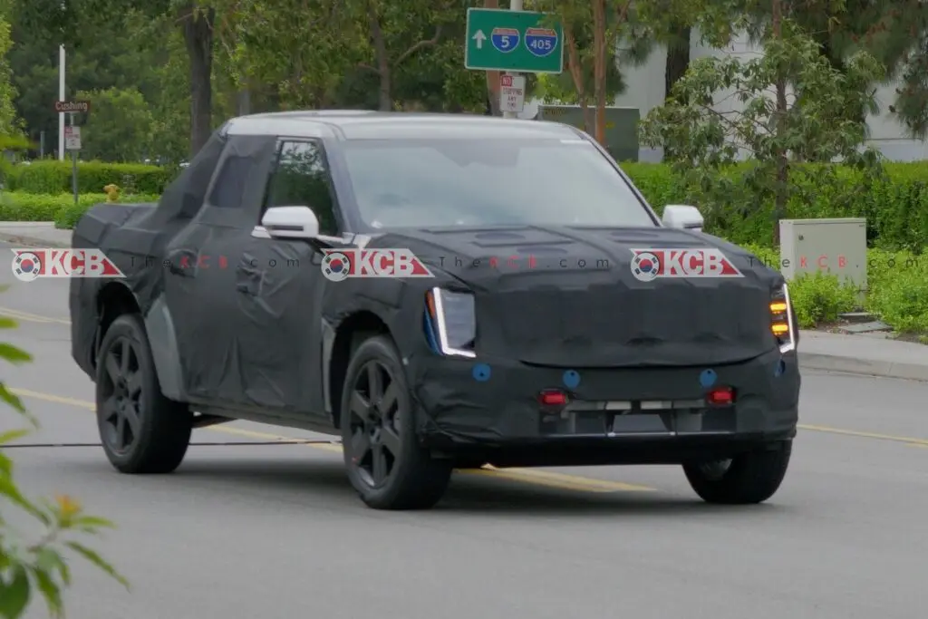 Camioneta negra camuflada en pruebas, circulando por una carretera.
