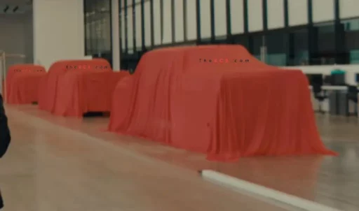 Vehículos cubiertos con telas rojas en un espacio industrial.