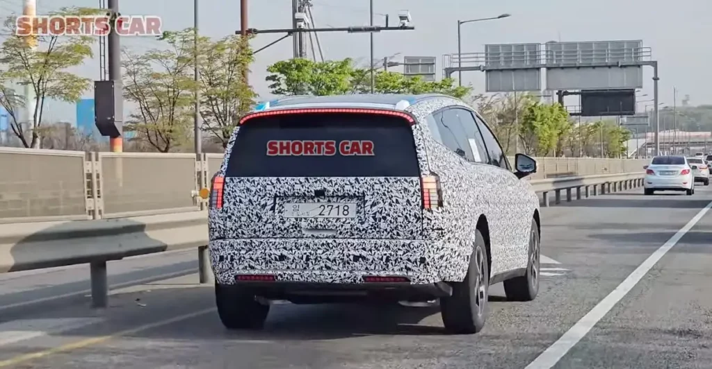 Vehículo con camuflaje de pruebas en una autopista urbana.