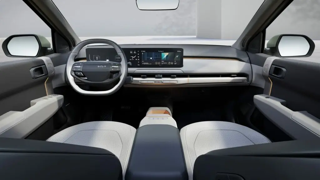 Interior moderno de auto eléctrico con pantalla táctil y volante innovador.