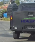 Camioneta negra cubierta en camino rural, logo HEALER TV visible.