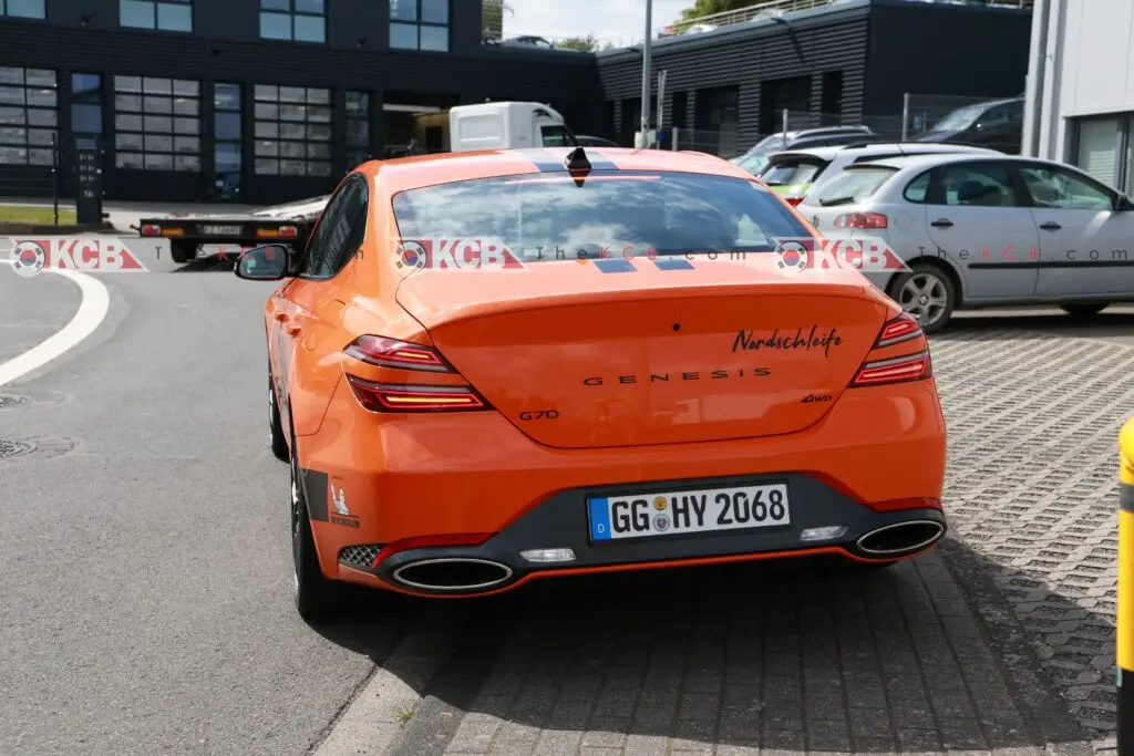 Automóvil naranja Genesis G70 en estacionamiento al aire libre.