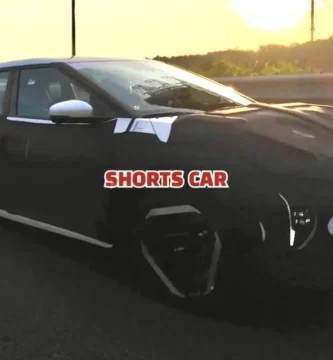 Coche camuflado en carretera al atardecer con el logo "SHORTS CAR".