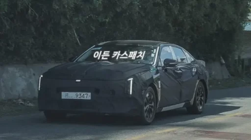 Automóvil camuflado en carretera con texto en coreano sobreimpreso.