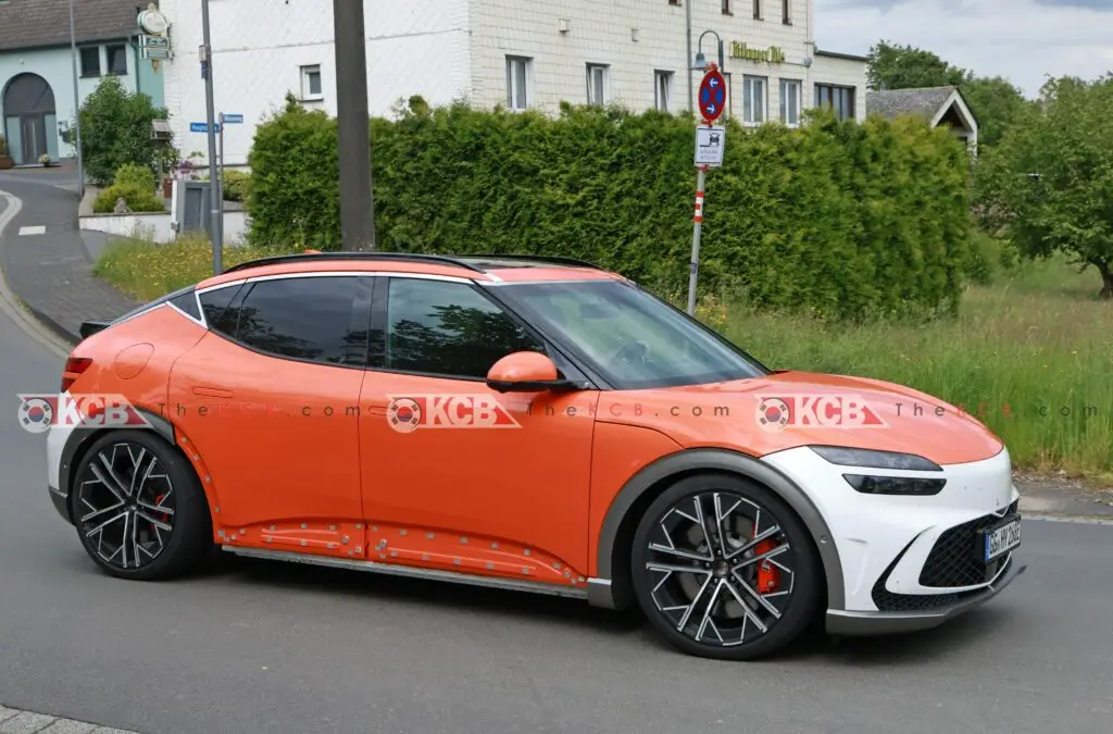 Coche naranja y blanco estacionado en una calle suburbana.