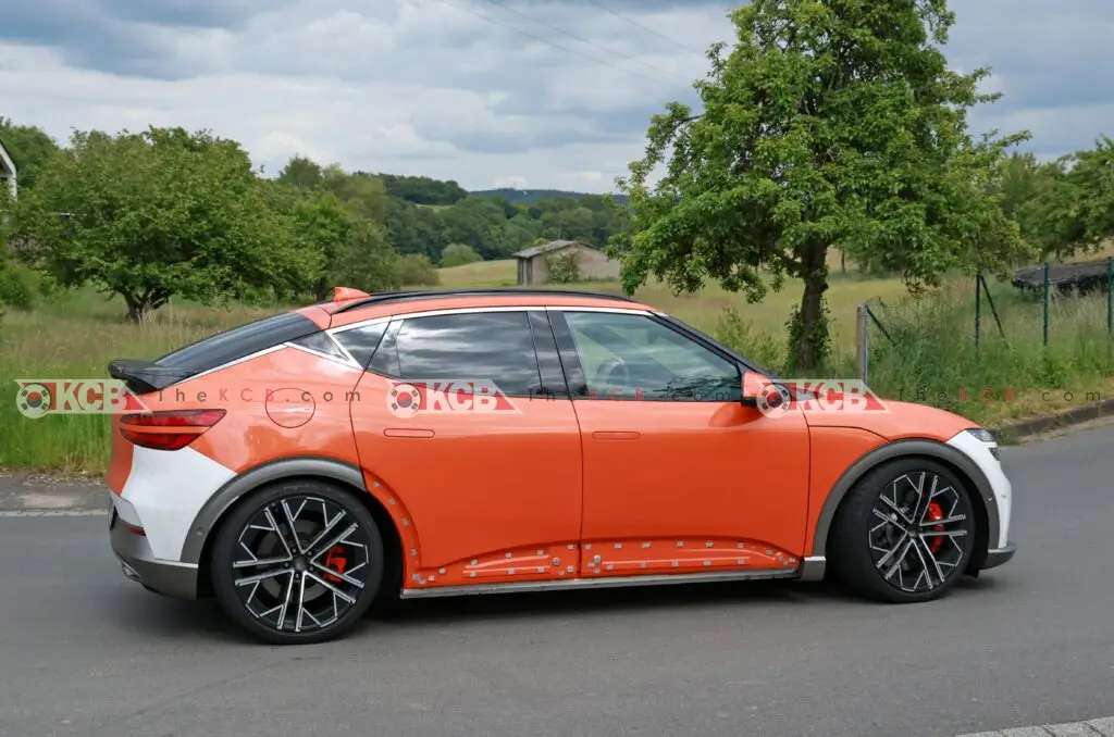 Coche deportivo naranja estacionado en una carretera rural.