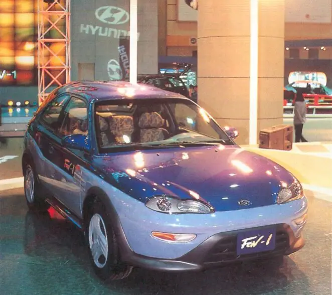 Coche compacto azul y gris en exhibición en un showroom Hyundai.