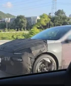 Auto en pruebas, parcialmente cubierto en una carretera.