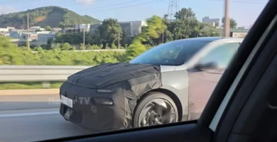 Auto en pruebas, parcialmente cubierto en una carretera.