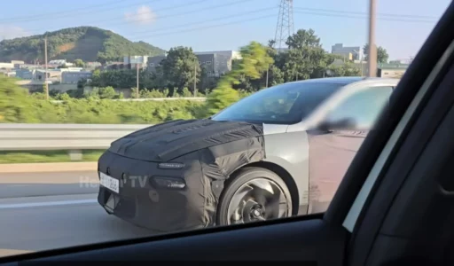 Auto en pruebas, parcialmente cubierto en una carretera.