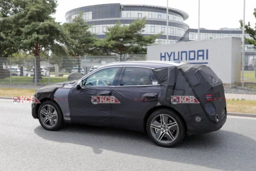 Vehículo camuflado frente a edificio Hyundai, en fase de prueba.