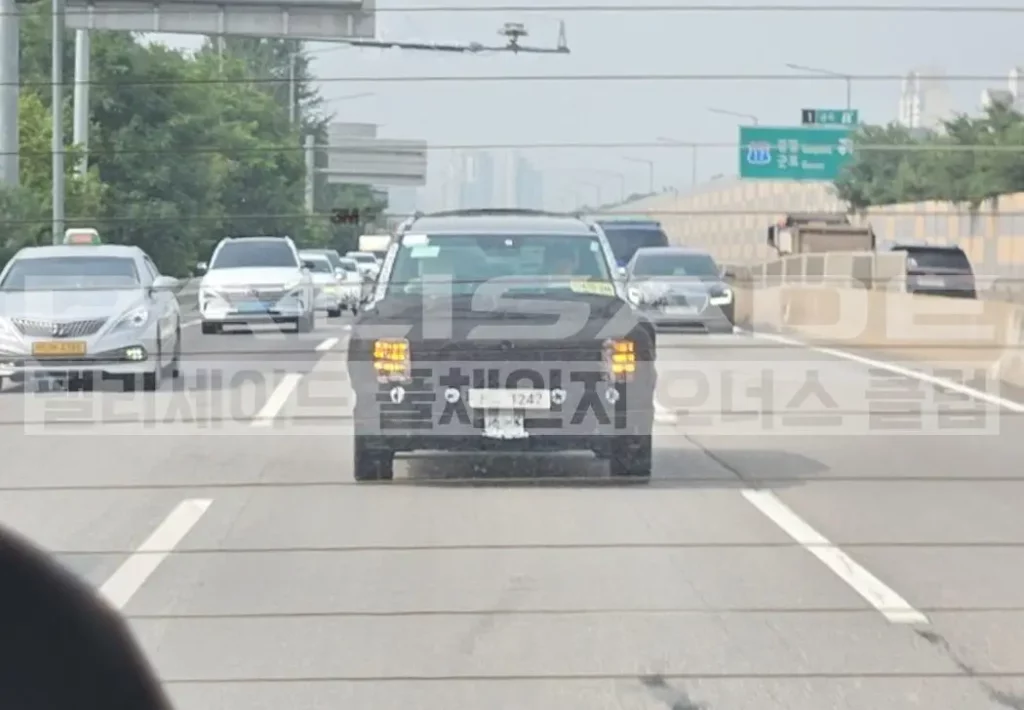 Autos circulando por una carretera con vegetación al fondo.