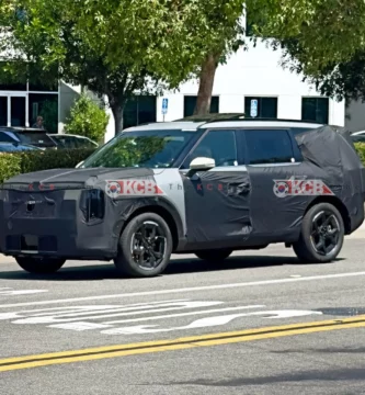 SUV camuflado en prueba, transitando en una calle urbana.