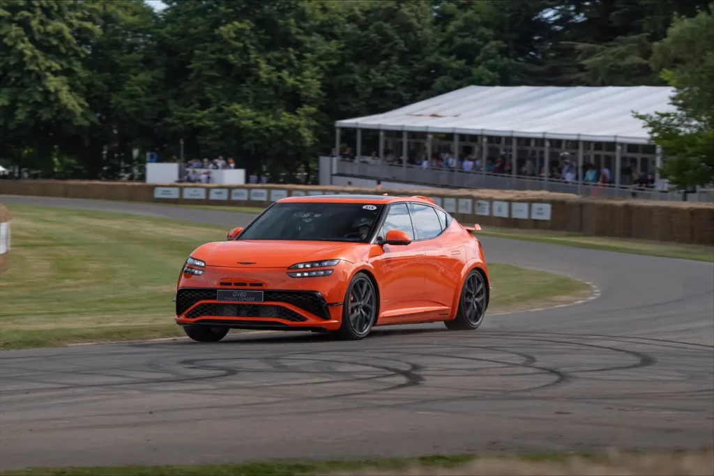 Coche deportivo naranja girando en una pista curva.