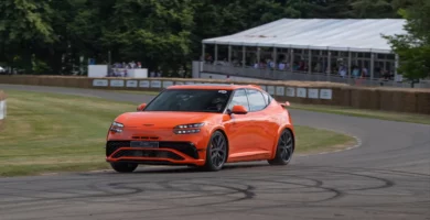 Coche deportivo naranja girando en una pista curva.