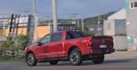 Camioneta roja Ford en una calle urbana.