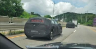 Auto camuflado en carretera, texto "SHORTS CAR" visible.