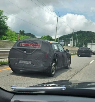 Auto camuflado en carretera, texto "SHORTS CAR" visible.