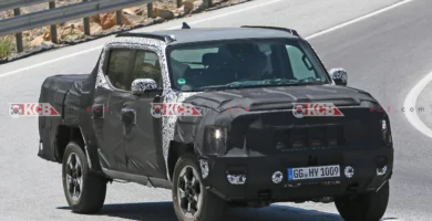 Camioneta negra parcialmente camuflada en prueba de carretera.